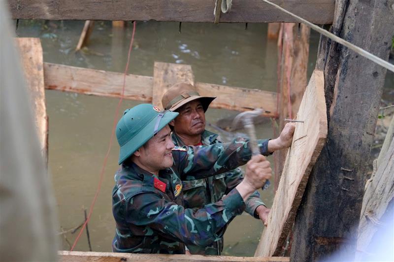 Cán bộ, chiến sĩ LLVT tỉnh Lâm Đồng giúp người dân xã Đam Rông 2 làm cầu sau khi bị lũ cuốn trôi